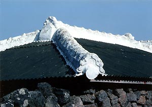 (写真4)済州島北東部の漁村で見た民家の屋根の強風対策。 茅はスレートに代わり棟の瓦は石灰でしっかりと固められている。 1999年10月 吉野撮影©