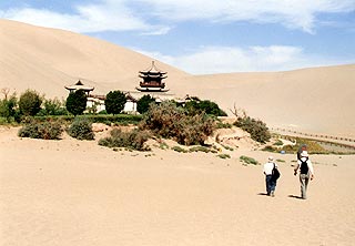 （写真1）敦煌の南南西約5ｋｍにある鳴沙山の横にある月牙泉（げつがせん）（画面右）とその横にある廟（びょう）。中国語では宙宇（ミャオユー）。 2002年8月9日、吉野撮影©